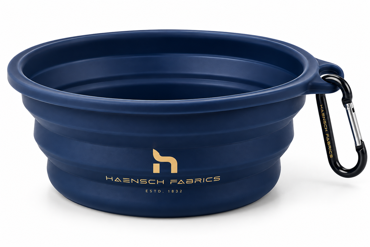 Faltbarer Haensch Coast Travel Bowl in Deep Navy mit goldenem Haensch Fabrics Logo und Karabiner auf weißem Hintergrund.