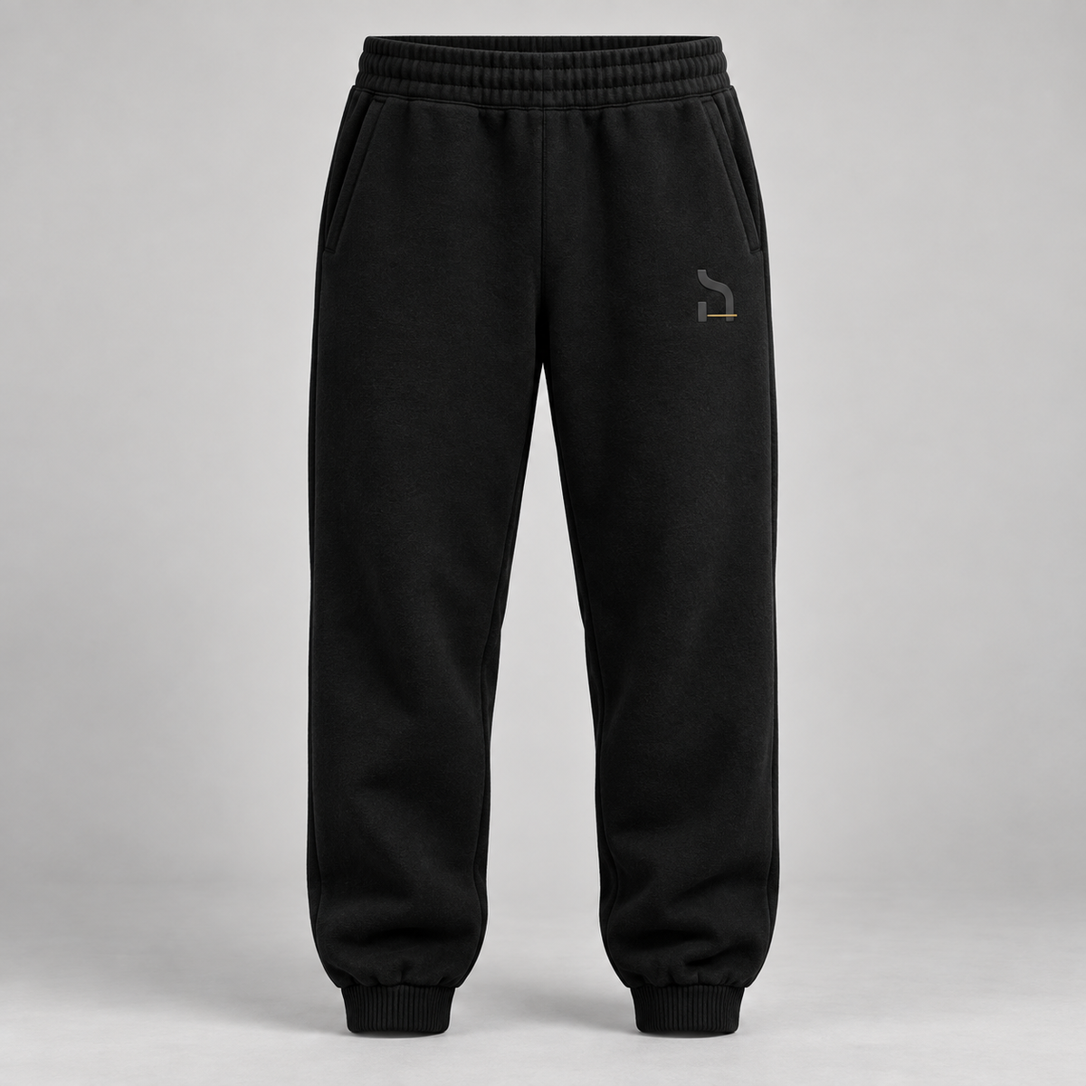 Schwarze Haensch Studio Ultra Heavy Sweatpants in Vorderansicht mit tonalem Hänsch-Zeichen und kurzem altgoldenen Akzent.