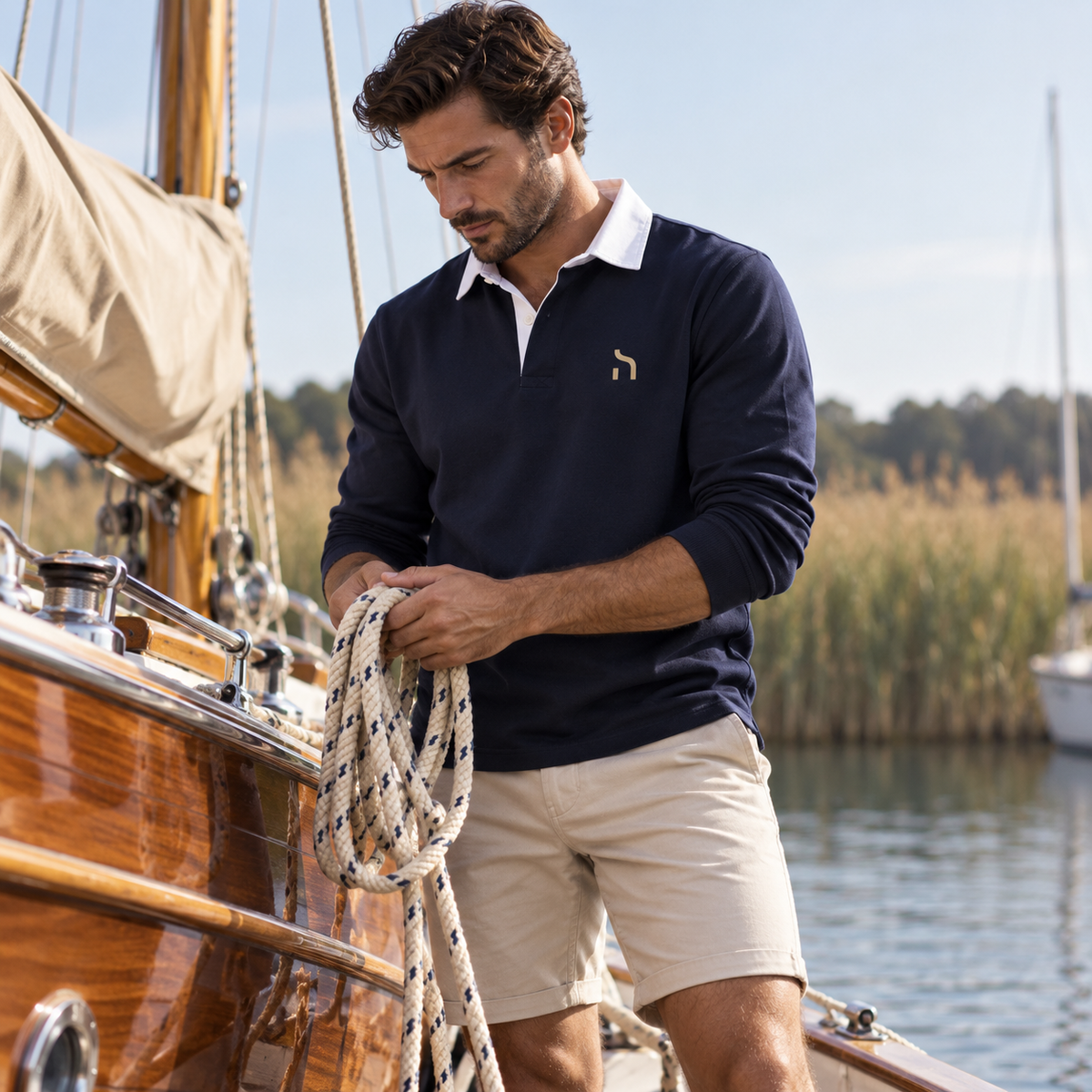 Mann trägt maritime Herrenmode von Haensch Coast in Navy und Weiß am Ostseestrand.