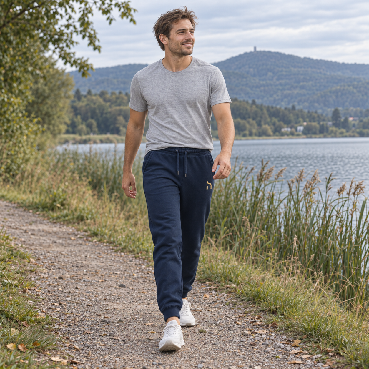 Sportlicher junger Mann in marineblauer Haensch Utility Premium Jogger am Olbersdorfer See.
