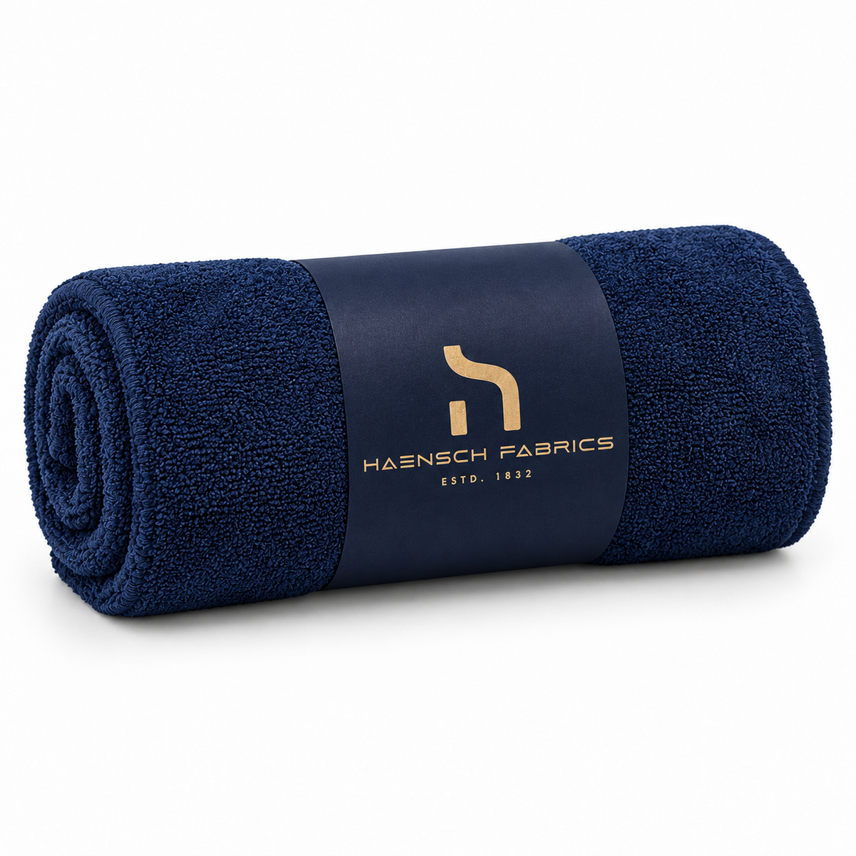 Gerolltes Haensch Coast Dog Drying Towel in Deep Navy mit goldfarbenem Haensch Fabrics Branding und Verpackungsband.