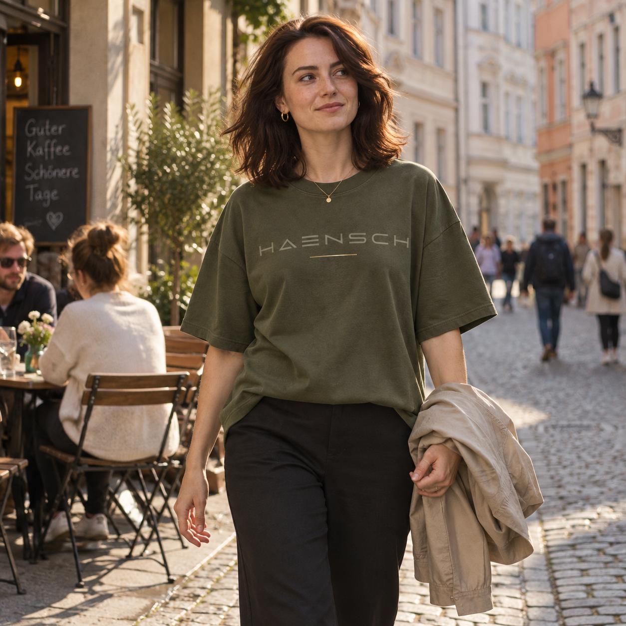 Junge Frau trägt das olivfarbene Haensch Studio Oversized Box T‑Shirt in der historischen Görlitzer Altstadt.