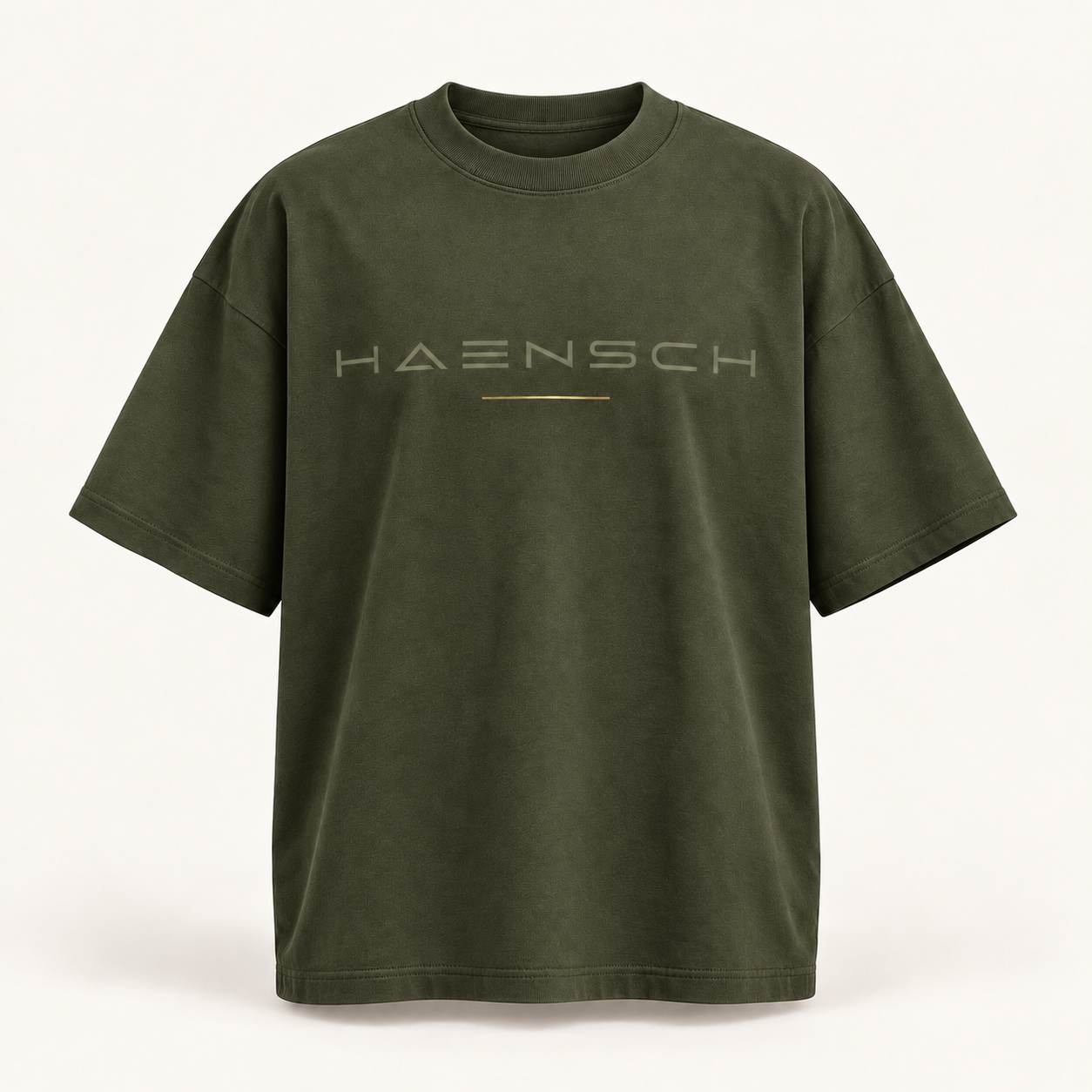 Olivfarbenes Haensch Studio Oversized Box T‑Shirt mit tonalem HAENSCH-Schriftzug und feiner goldener Linie in der Vorderansicht.