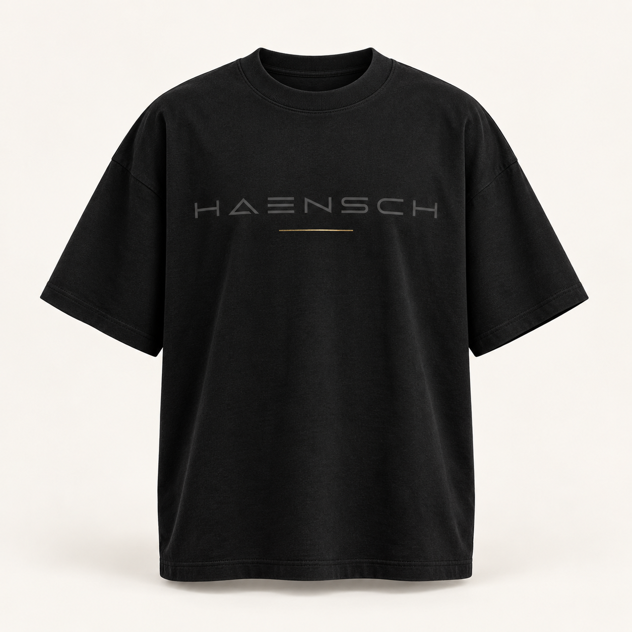 Schwarzes Haensch Studio Oversized Box T‑Shirt mit tonalem HAENSCH-Schriftzug und feiner goldener Linie in der Vorderansicht.
