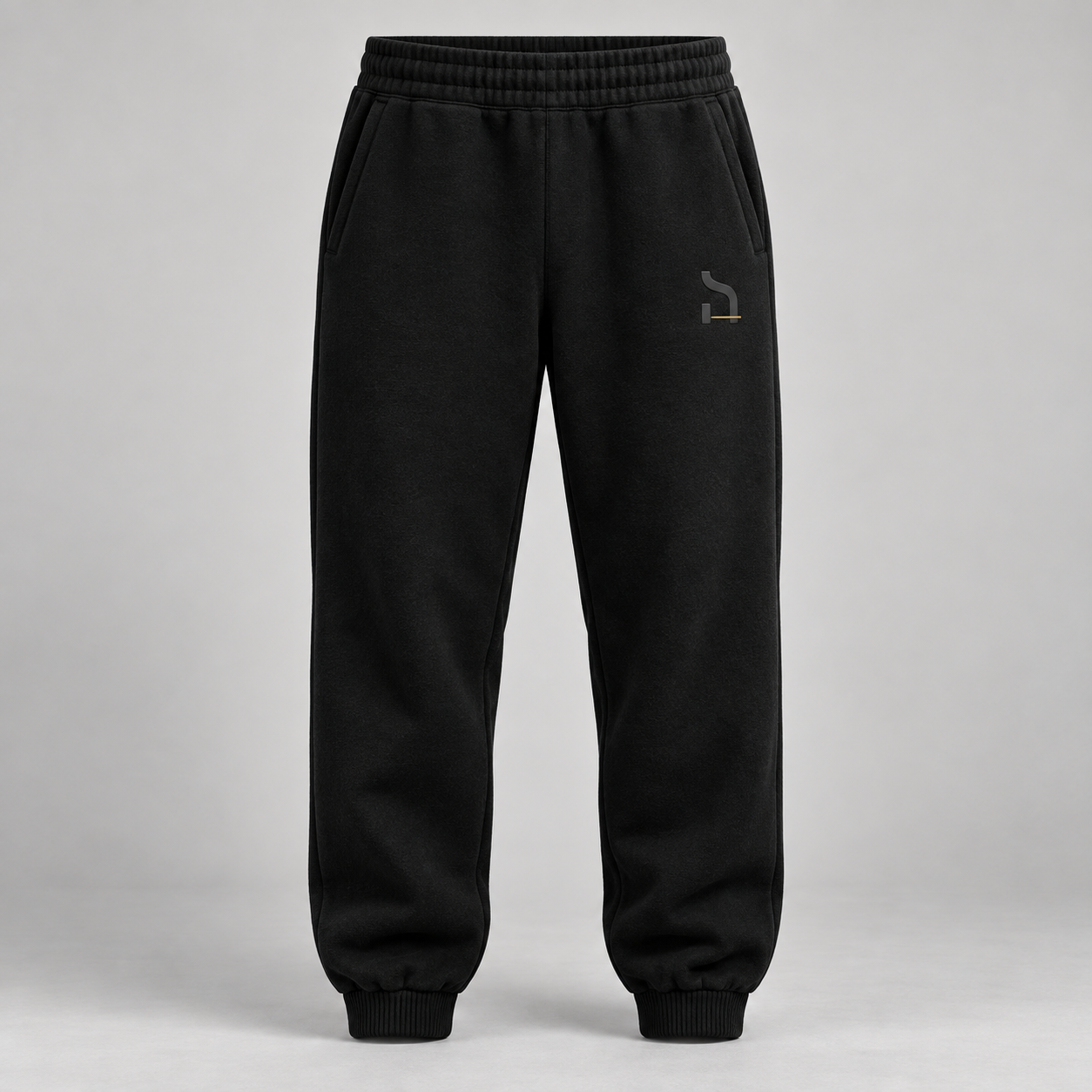 Schwarze Haensch Studio Ultra Heavy Sweatpants in Vorderansicht mit tonalem Hänsch-Zeichen und kurzem altgoldenen Akzent.