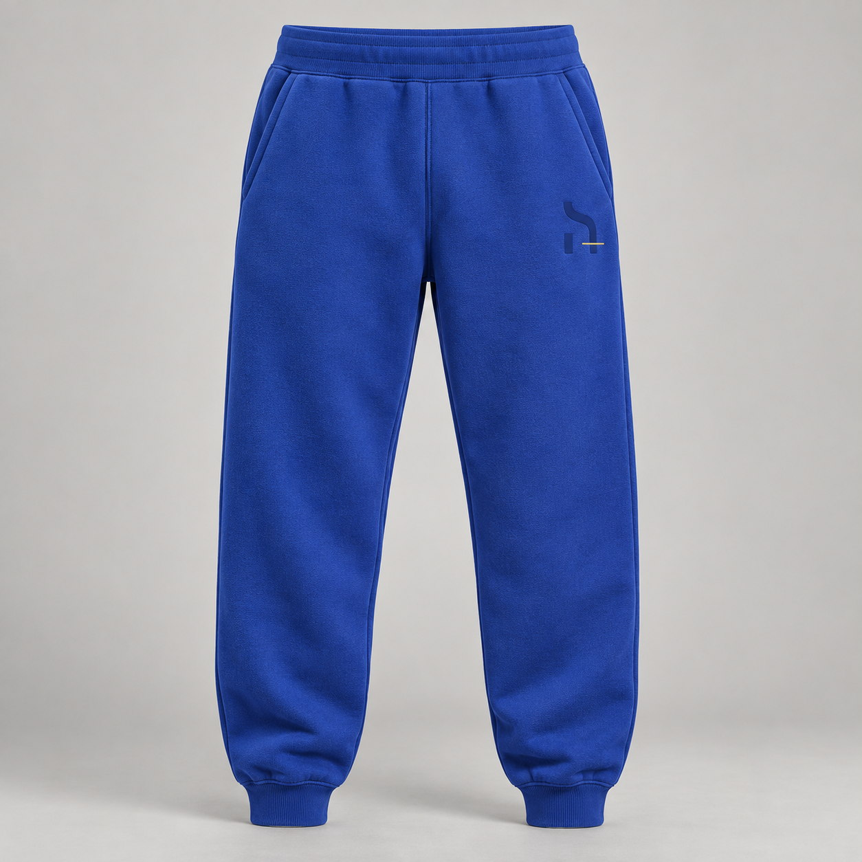 Cobaltblaue Haensch Studio Ultra Heavy Sweatpants in Vorderansicht mit tonalem Hänsch-Zeichen und kurzem altgoldenen Akzent.