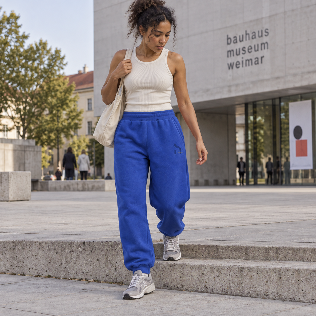Junge Frau trägt die cobaltblauen Haensch Studio Ultra Heavy Sweatpants vor dem Bauhaus-Museum Weimar.