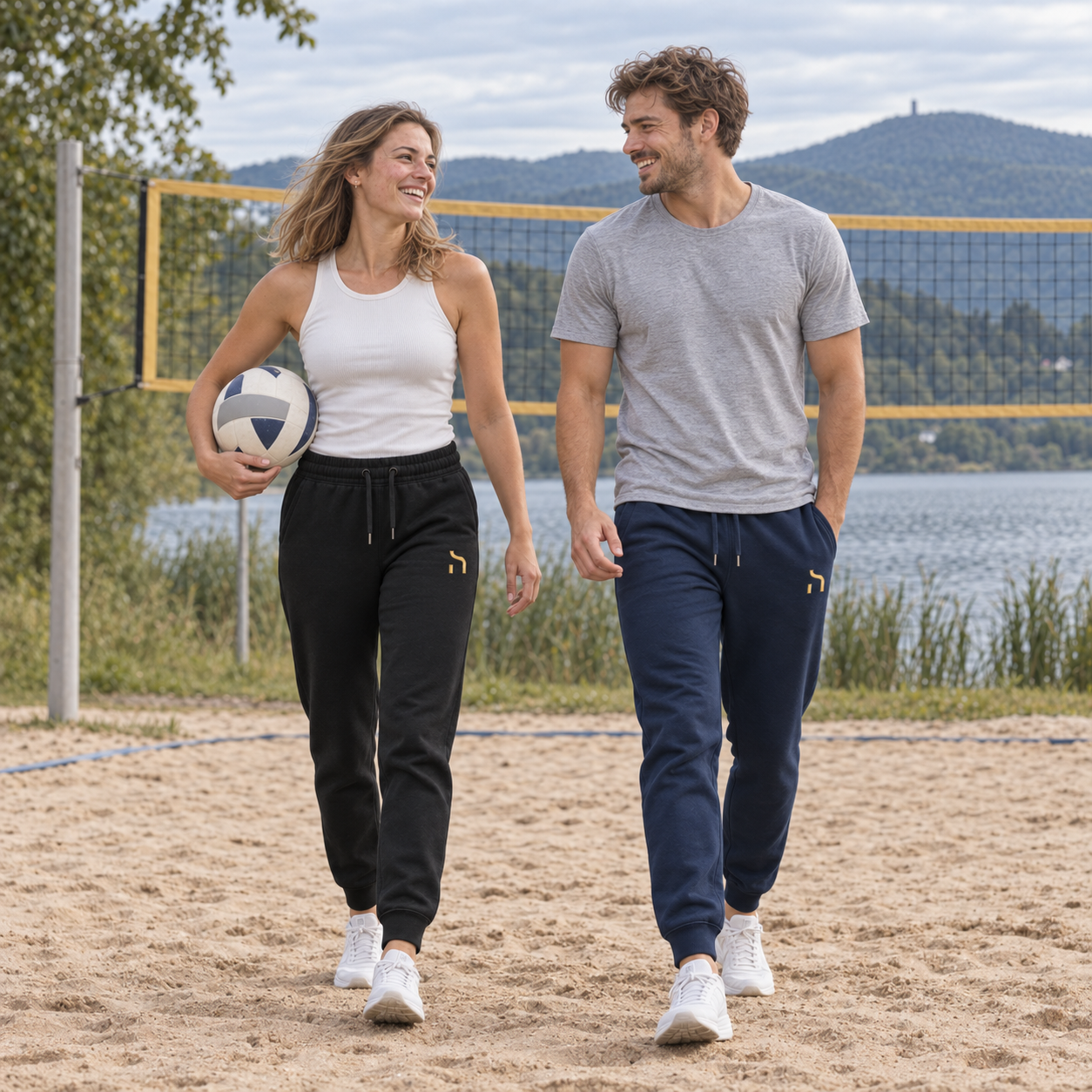 Junge Frau in schwarzer und junger Mann in marineblauer Haensch Utility Premium Jogger beim Volleyball am Olbersdorfer See.
